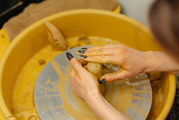 Hands expertly shaping clay on a pottery wheel, gracefully showcasing the beautiful art of ceramics