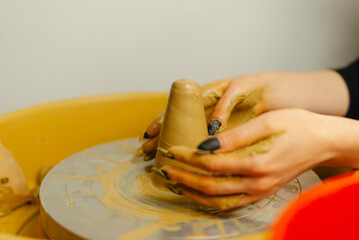 An experienced potter skillfully creates a beautiful piece of art using clay while working on a spinning wheel