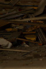 A large pile of various junk is sitting on the floor inside an untidy room, creating a messy atmosphere that is hard to ignore