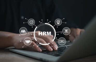  Businessman's hands typing on laptop with HRM digital interface overlay, representing human resource management, employee data, recruitment, training, payroll, and organizational performance.