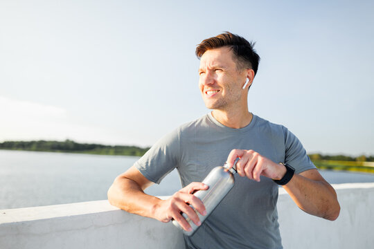 Man enjoys a refreshing moment by the water while staying active and hydrated