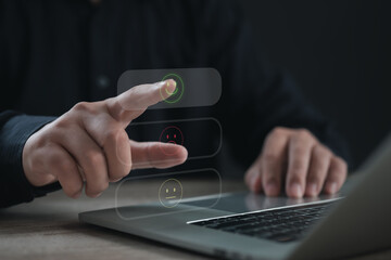 Business professional selecting a happy face icon on a digital feedback form via laptop, representing customer satisfaction, service evaluation, and positive user experience in business platforms.
