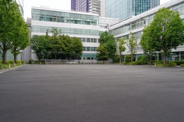 A large empty parking lot in front of the atrium building at Shibuya, Japan The asphalt surface is clean and smooth with no vehicles or people present Generative AI