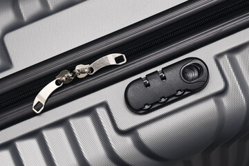Secure travel suitcase detail. Close up of silver luggage zipper and safety lock. Modern hard shell...