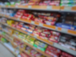 Blurry image of a supermarket aisle with shelves full of products. An abstract retail background for business, shopping, supermarket concepts, or consumer markets.