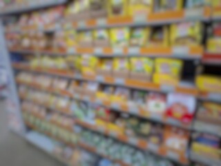 Blurry image of a supermarket aisle with shelves full of products. An abstract retail background for business, shopping, supermarket concepts, or consumer markets.