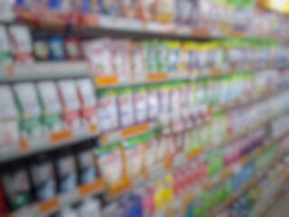 Blurry image of a supermarket aisle with shelves full of products. An abstract retail background...