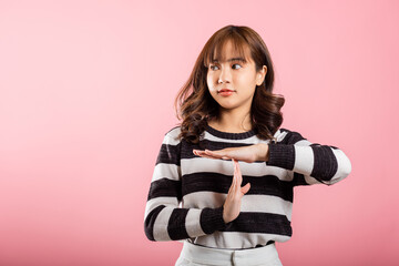 Closeup portrait young woman smiling making time out gesture with hands studio shot isolated on...