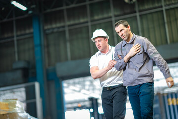 Young male coworker helps injured older worker after warehouse accident. Strong visual for safety...
