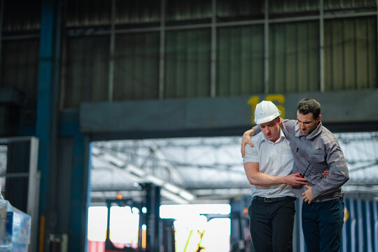Logistics worker rushes to assist senior colleague injure. Perfect for workplace safety campaigns, teamwork culture, and first aid response in industrial settings.