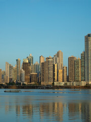 Fototapeta premium Modern skyline of Panama City reflected on coastal waters at sunset