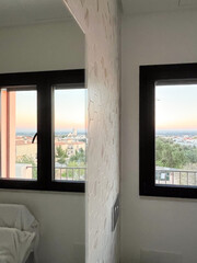 Modern interior design featuring hexagonal tile wall, large windows with scenic view, and soft...