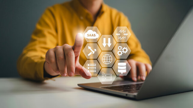 A person touches a screen displaying a grid of hexagonal icons representing saas, cloud computing, data, and network services, highlighting digital business solutions