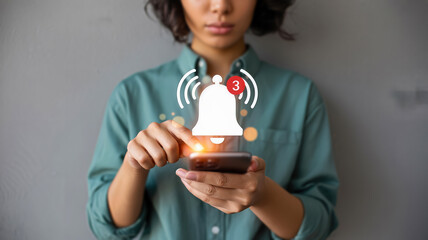 A person uses a smartphone, with a notification alert icon appearing above the screen, symbolizing digital communication and updates