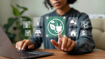 A person touches a glowing green icon of a power plug with a leaf, surrounded by symbols of renewable energy and environmental sustainability