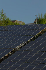 A long row of efficient solar panels extending elegantly against a bright blue sky, harnessing...