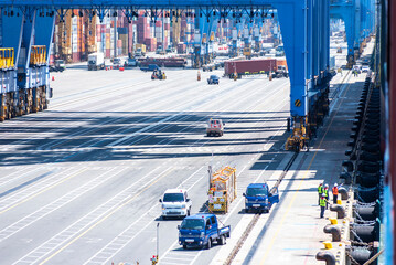 Busan, South Korea - container terminal, view below gantry cranes near the moored ship.