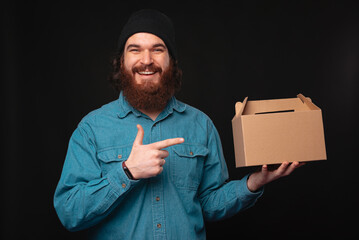 A cheerful man excitedly showcases a cardboard box while emphasizing the importance of delivery...