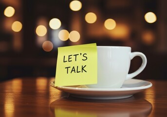 A white cup with a sticky note on a table with bokeh light background