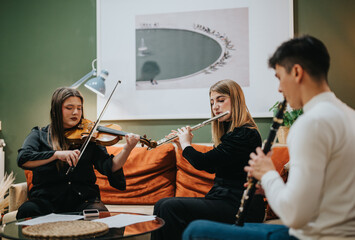Young musicians rehearsing together indoors, passionately playing violin, flute, and clarinet in...