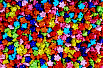 bright multi-colored bow tie-shaped beads scattered across the surface