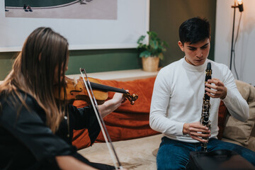 Two young musicians, a violinist and a clarinetist, practicing their instruments together in a warm...