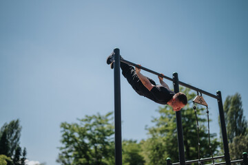A person demonstrates strength and skill in calisthenics exercises on outdoor equipment against a...
