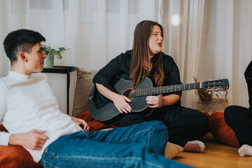 A woman playing guitar and singing, with friends relaxing nearby in a cozy room. Captured in a...