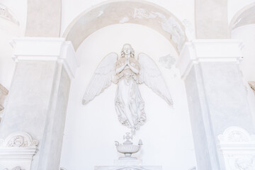 Ancient statue of angel in Italian old cemetery. Religious sculpture, no people, grey marble