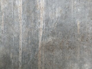 Streaked Concrete Wall Texture. A close-up of a weathered concrete wall, displaying vertical streaks and variations in grey tones, ideal for backgrounds