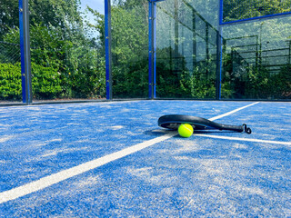 Competition-ready padel equipment awaits players on the pristine court surface, showcasing the professional aspects of this energetic sport. 
