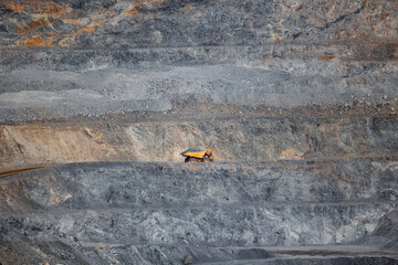 Massive Mining Truck in an Open-Pit Mine Showcasing Industrial Scale and Geological Layers