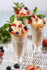 Japanese crepes with whipped cream filling, strawberries, blueberries, almond petals, garnished with mint.  