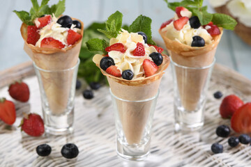 Japanese crepes with whipped cream filling, strawberries, blueberries, almond petals, garnished with mint.  