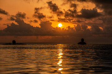 Couple enjoying sunset in infinity pool on the Black Sea coast, romantic evening swim with sunset...