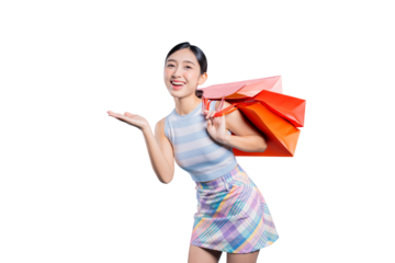 A cheerful young Asian woman with shopping bags, making a presenting gesture with her open hand to showcase a product or sale.on png
