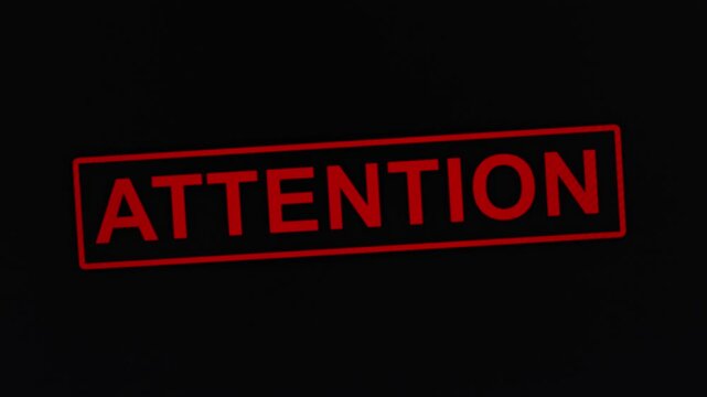 Animated red stamp attention on black background, concept of warning about danger or drawing attention to a problem