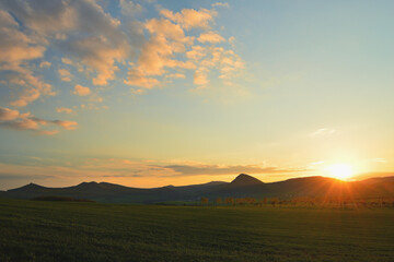 Colorful Sunset over Silhouetted Hill Ridge with Spectacular Clouds in the Sky