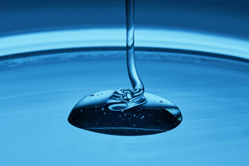 The texture of a cosmetic product in the form of jelly or gel on a blue background.