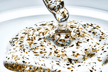 Serum with 24k gold particles is poured from a pipette. The texture.