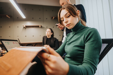Focused individuals working together in a modern office environment, brainstorming and reviewing...