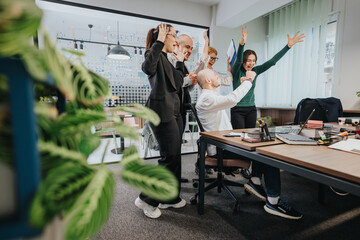 A group of happy colleagues celebrating a milestone achievement in a collaborative workspace, with...