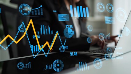 A business professional engages with data visualization on a laptop, surrounded by innovative...