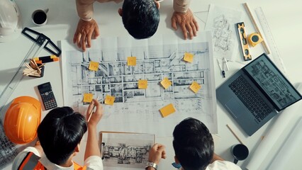 Top down aerial view of smart architect engineer team pointing and discussing about building...