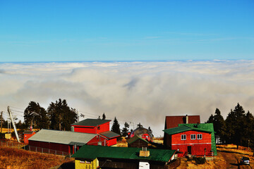 Aerial View of Hilltop Buildings Emerging from Inversion and Low Clouds