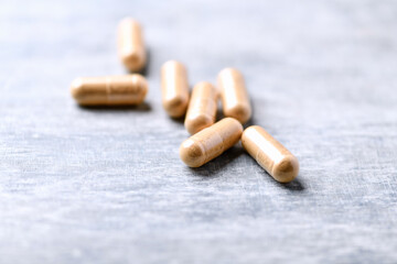 Korean Ginseng capsules. Concept for a healthy dietary supplementation. Wooden background. Soft focus. Close up.	