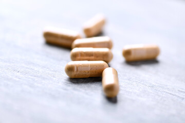 Korean Ginseng capsules. Concept for a healthy dietary supplementation. Wooden background. Soft focus. Close up.	