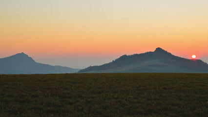 Colorful Sunrise with Hill Silhouettes in Red Soft Morning Light