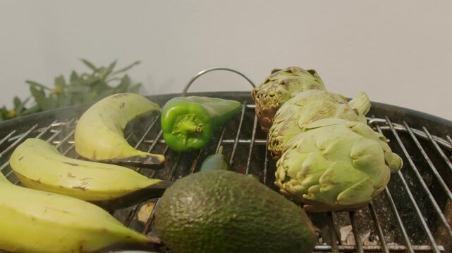 Grilled Banana on fire, latin american vegan grill with avocado and pepper, thai or Ecuadorian Street food. African traditional food on grill. 