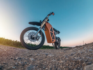 Creative photo of zoomed electric motorcycle low angle view. Arcing horizon with blue sky.